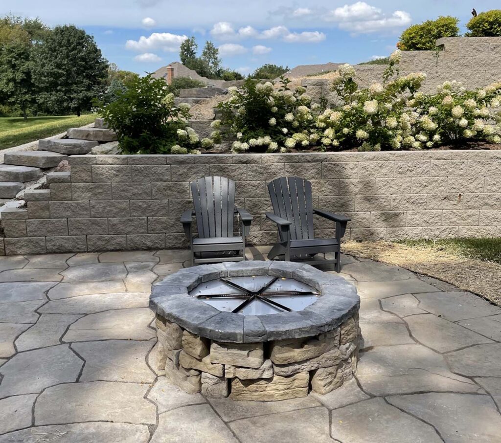 Stone patio with firepit and retaining walls